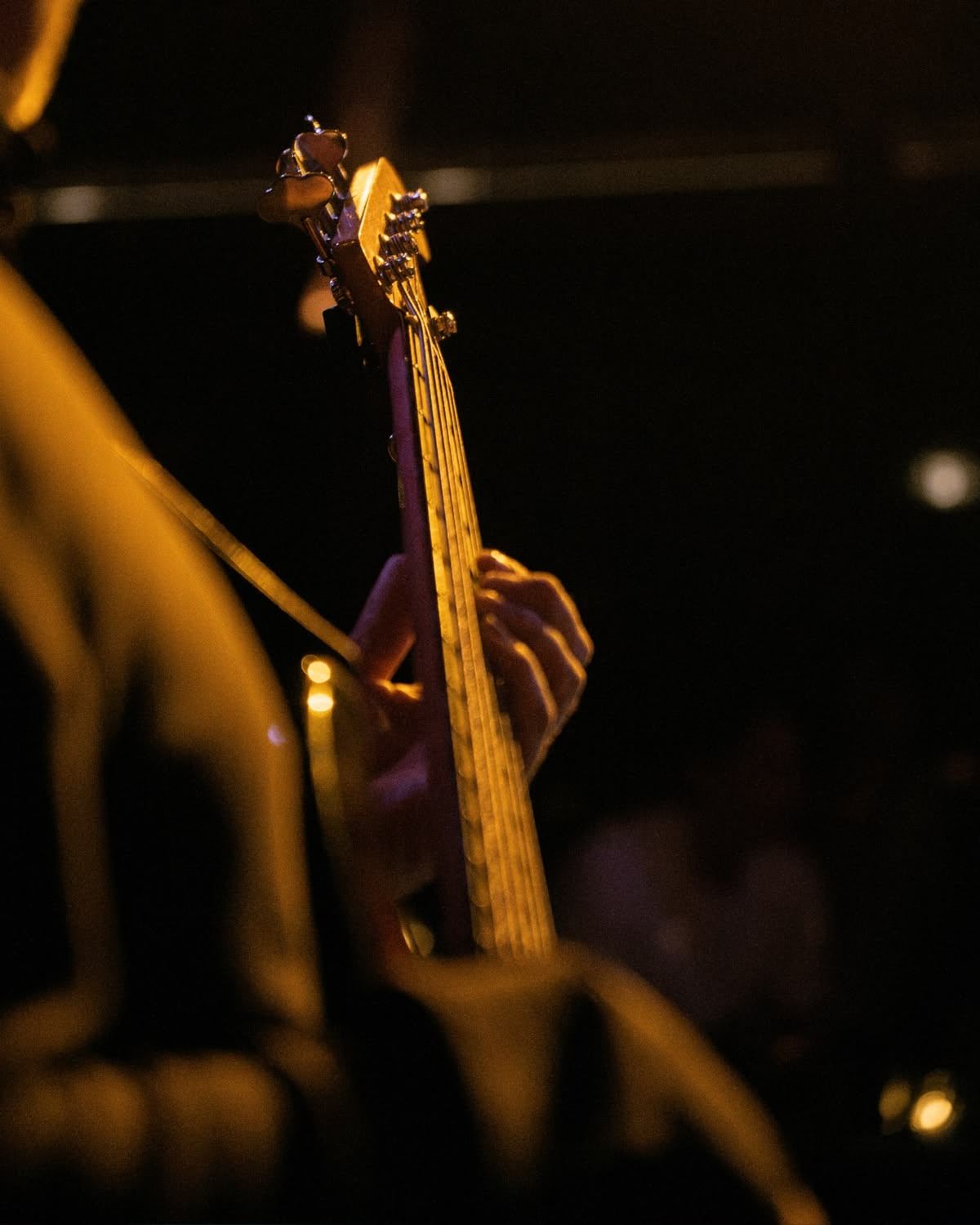 Musician silhouetted in warm amber stage light