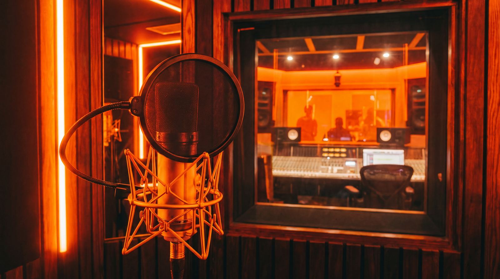 Studio microphone in the amber-lit vocal room